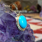 14kt gold Charles Johnson pendant with oval turquoise stone and sculptural gold setting.