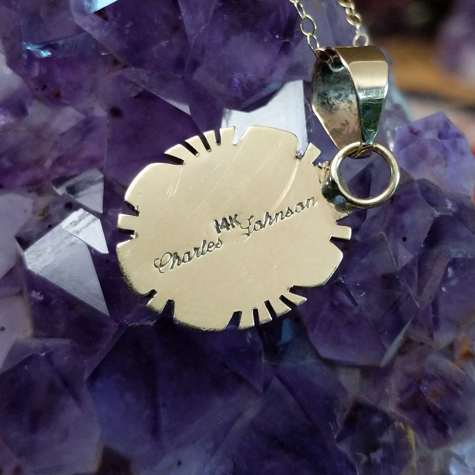 Close up of artist's stamped signature and 14K indicating 14 karat gold construction.
