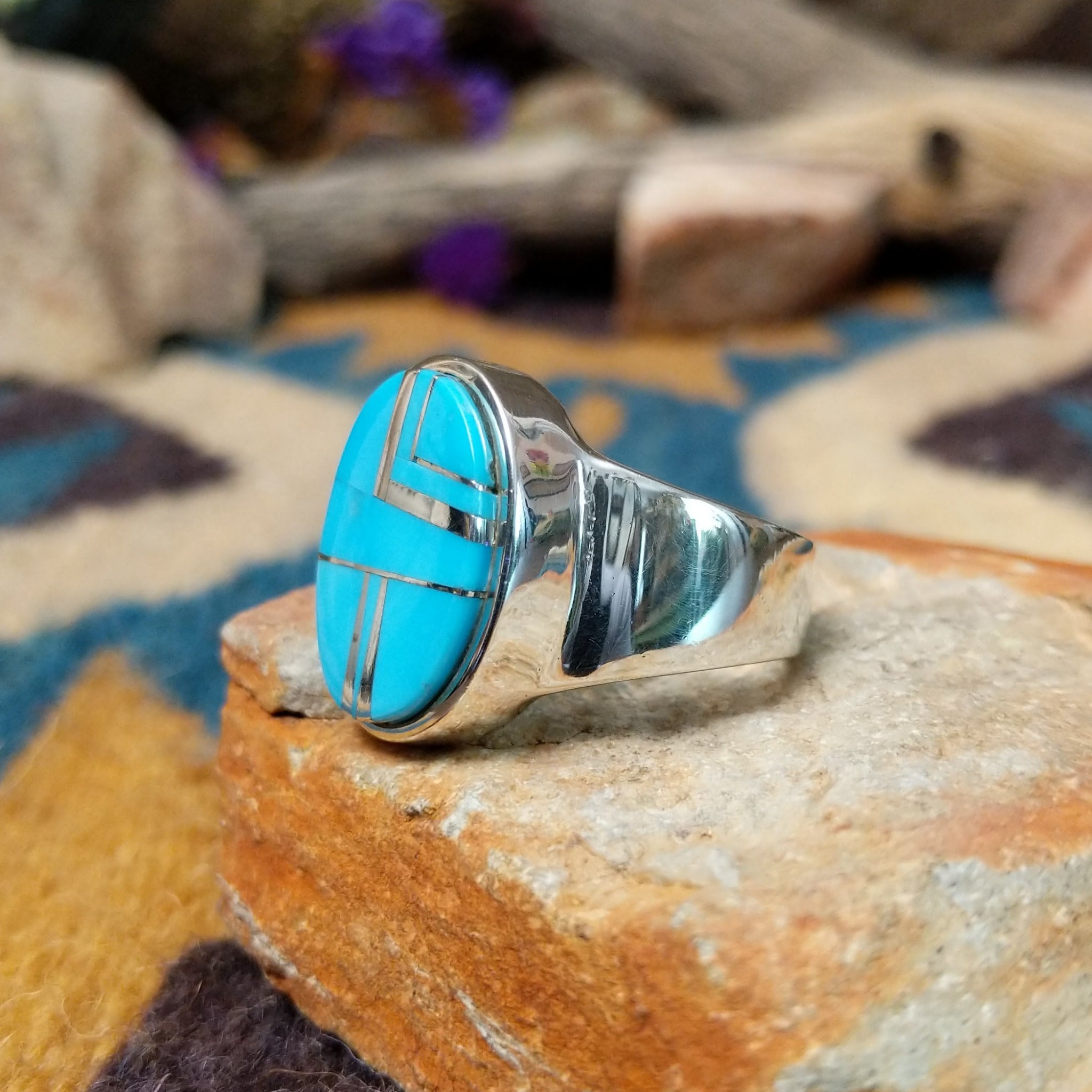 Sterling silver oval Turquoise inlay ring by Valerie Yazzie with geometric silver accents; side view.