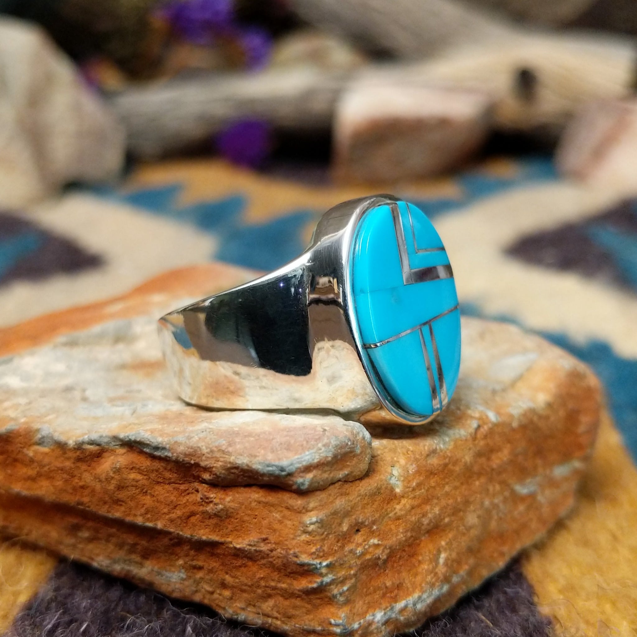 Sterling silver oval Turquoise inlay ring by Valerie Yazzie with geometric silver accents; side view.