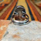 This distinctive Oval White Buffalo Ring by Everett & Mary Teller features a large oval white stone with bold black matrix patterns set in a smooth silver bezel; underside view.