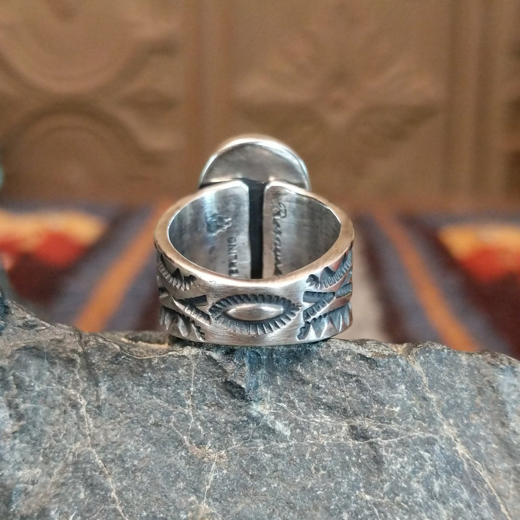 The band of the ring is stamped with various ornate detailing.