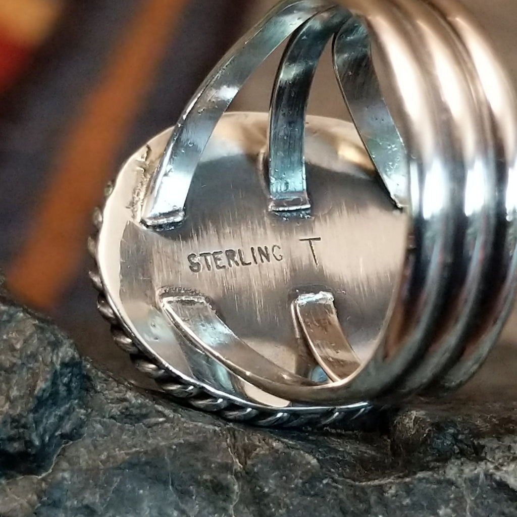 The underside of the bezel showcases the artist's initial and stamp.