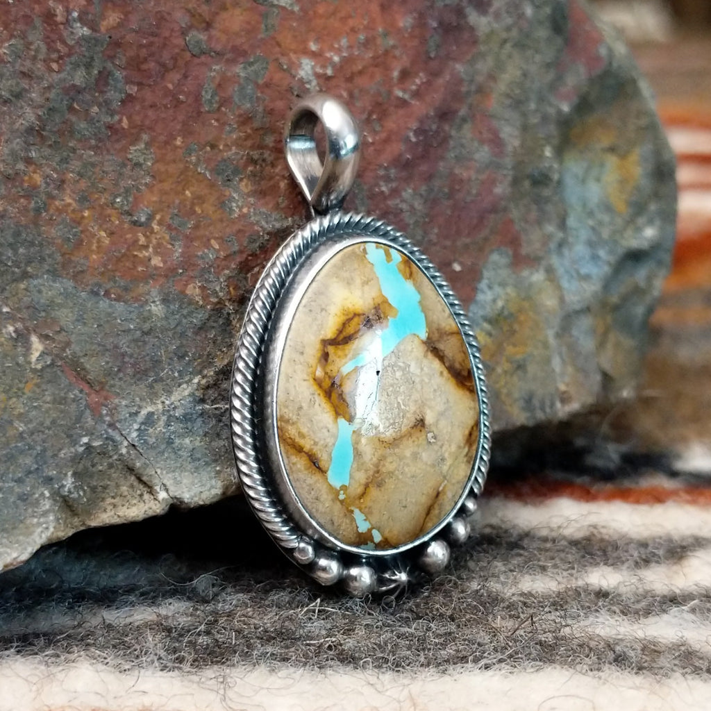 Sterling silver pendant with twisted rope and dotted accents, featuring boulder turquoise set in the bezel.