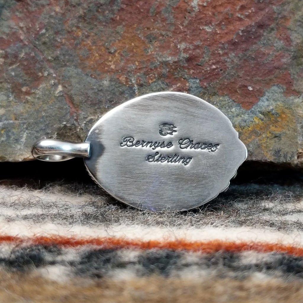 The back features the artisan's signature.