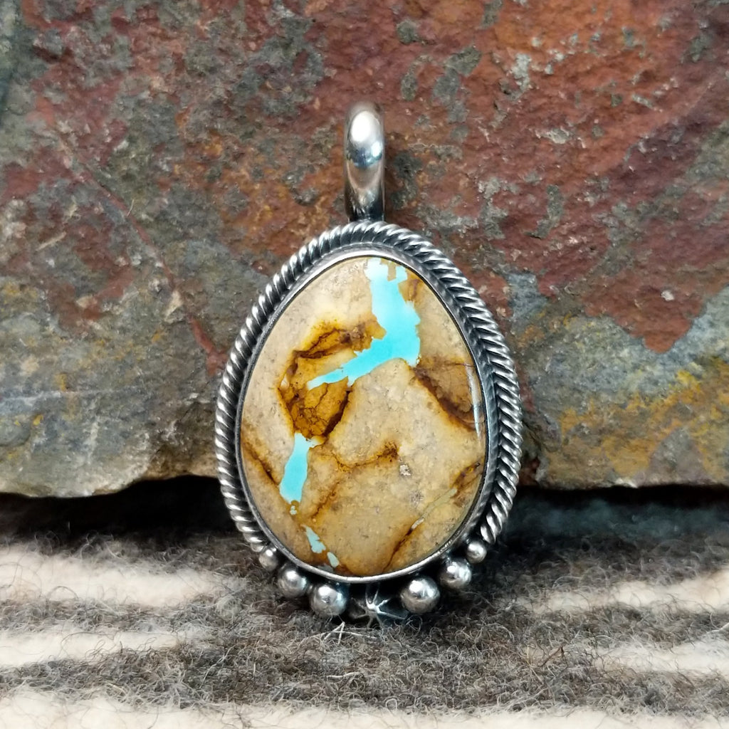 Sterling silver pendant with twisted rope and dotted accents, featuring boulder turquoise set in the bezel.