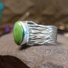 Sterling silver ring with Sonoran gold turquoise set in an oval bezel and strands of silver creating the band.