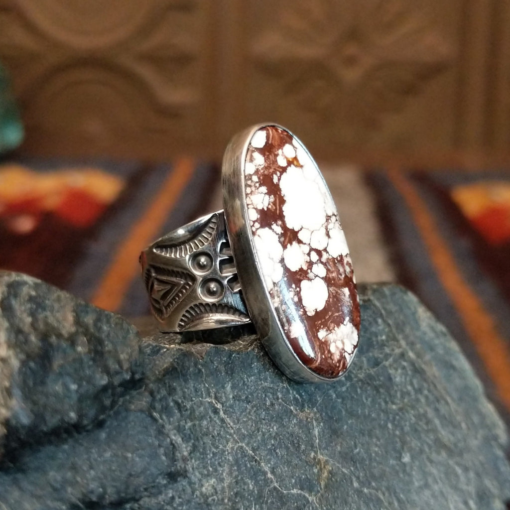 A wild horse stone within a sterling silver oval bezel, and an intricately detailed band.