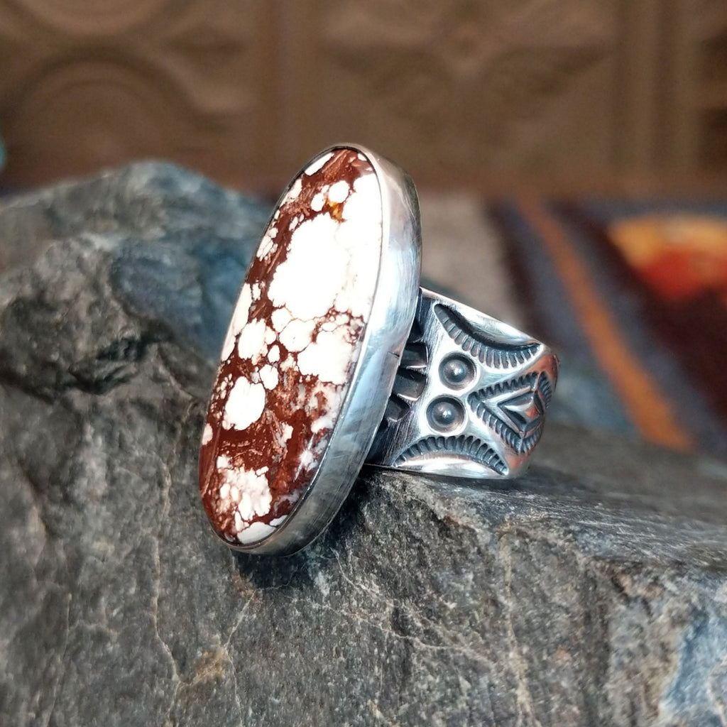 A wild horse stone within a sterling silver oval bezel, and an intricately detailed band.