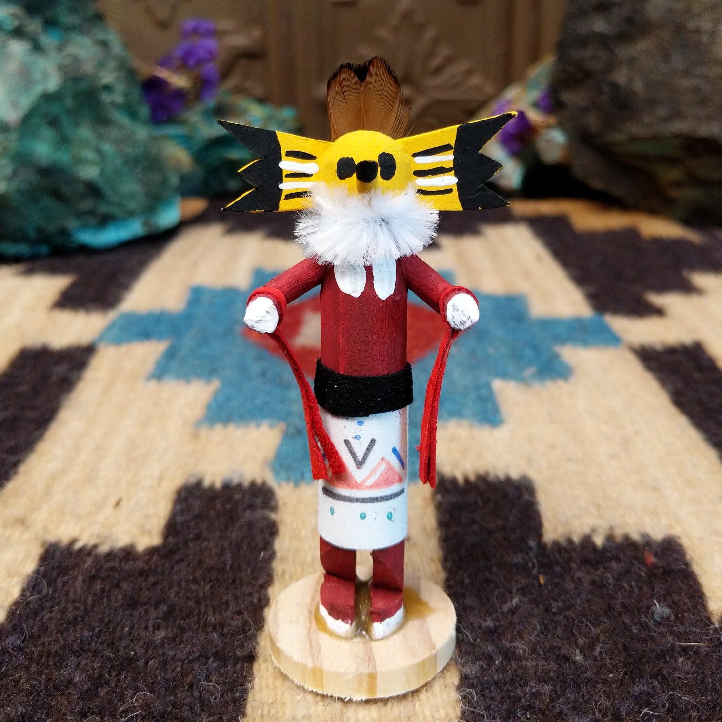 Mini owl kachina by Rosalind Grey with yellow face, white fur collar, red body, and white geometric-patterned garment.