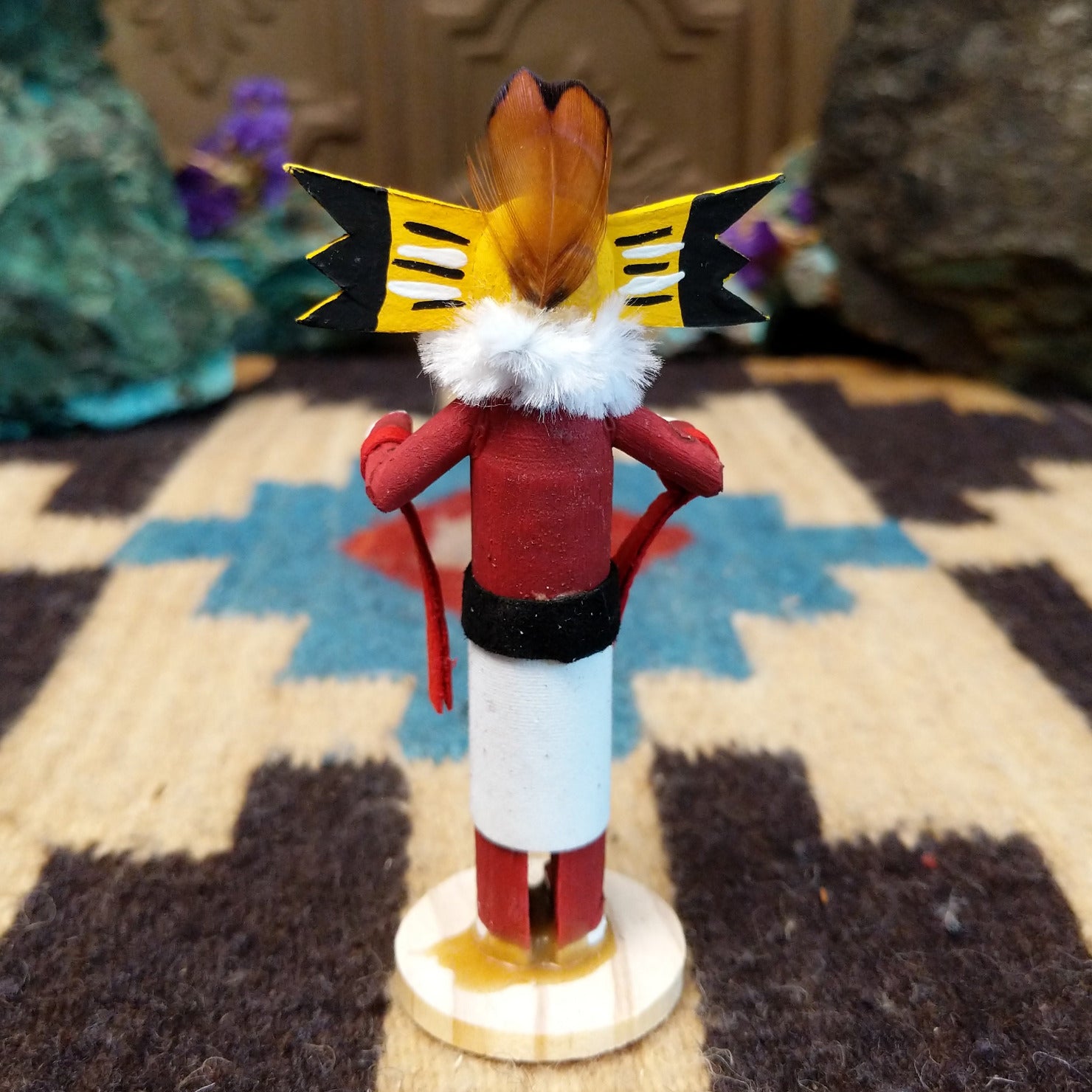 Mini owl kachina by Rosalind Grey with yellow face, white fur collar, red body, and white geometric-patterned garment.