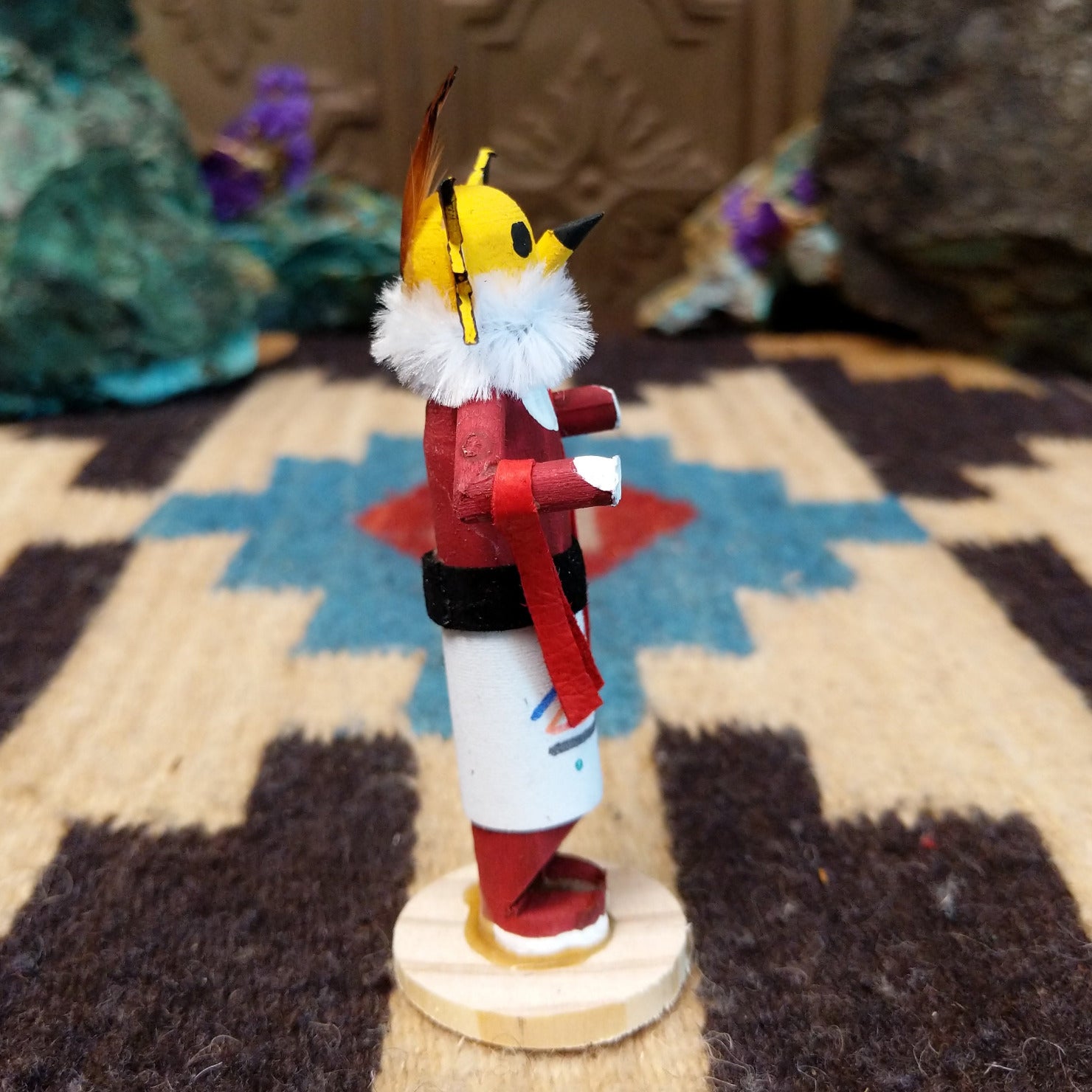 Mini owl kachina by Rosalind Grey with yellow face, white fur collar, red body, and white geometric-patterned garment.
