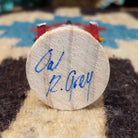 Underside of mini owl kachina doll showing handwritten signature and label on wood base.