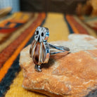 Rear view of an owl-shaped silver ring by Regina Kallestewa showing the smooth underside of the setting and polished split-shank band.