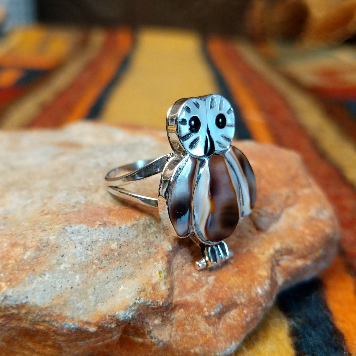 Rear view of an owl-shaped silver ring by Regina Kallestewa showing the smooth underside of the setting and polished split-shank band.