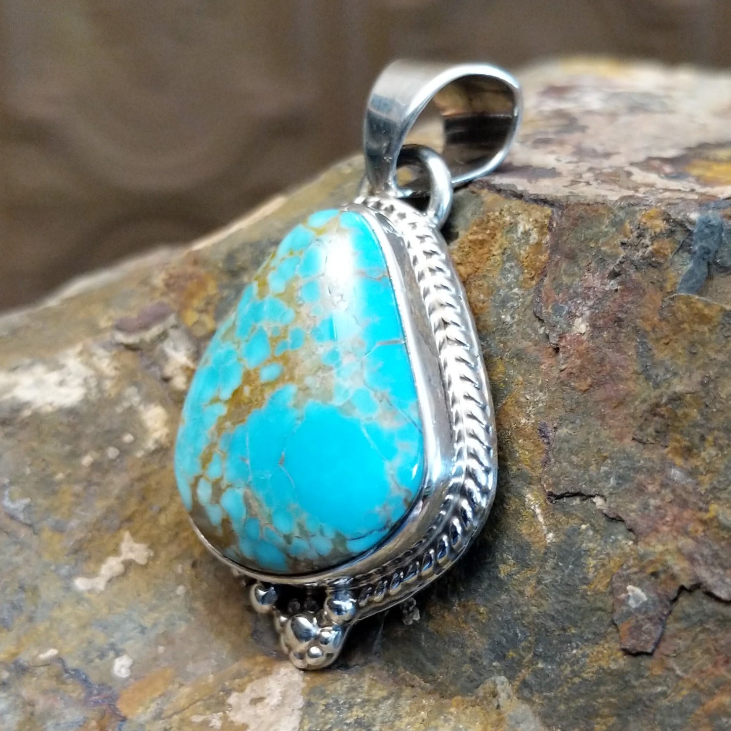 Genuine #8 Turquoise set in sterling silver with a rope accent detail.