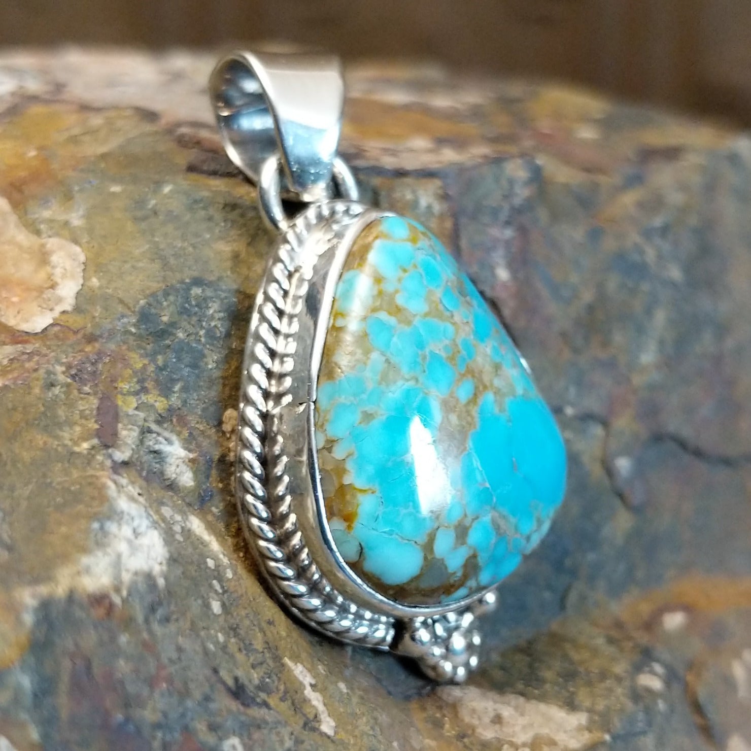 Genuine #8 Turquoise set in sterling silver with a rope accent detail.