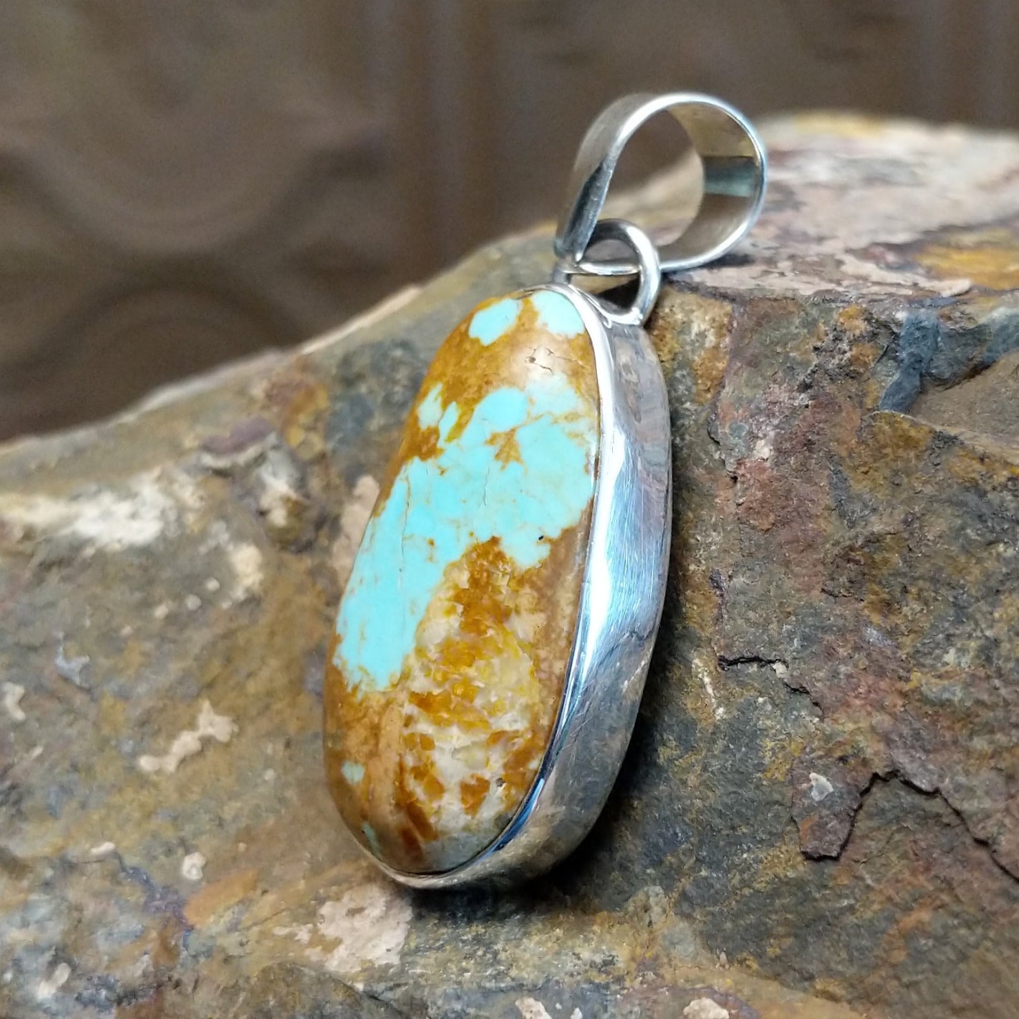 Handcrafted by Navajo artist L.P., this elliptic pendant features genuine #8 Turquoise set in sterling silver.