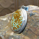 Handcrafted by Navajo artist L.P., this oval pendant features genuine #8 Turquoise set in sterling silver. 