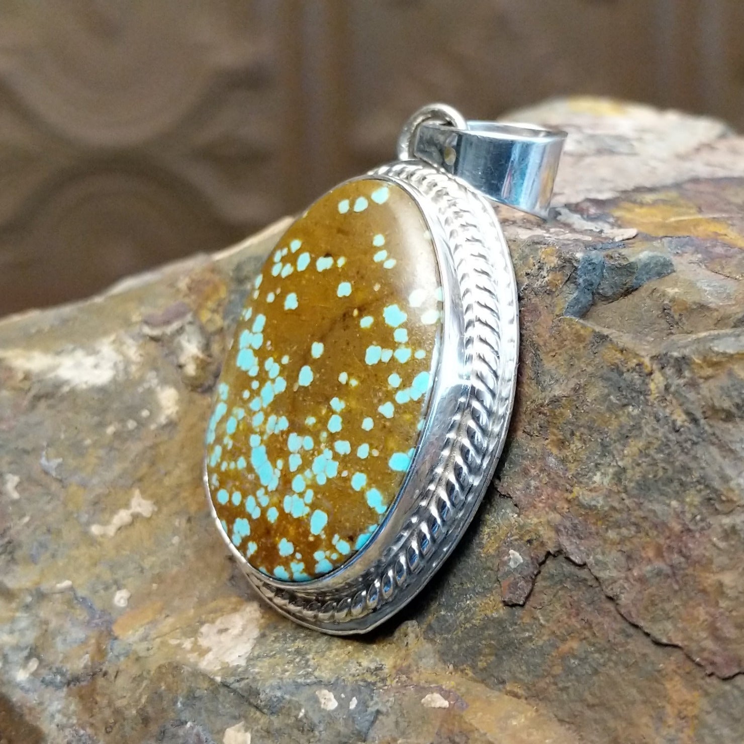 Handcrafted by Navajo artist L.P., this oval pendant features genuine #8 Turquoise set in sterling silver. 