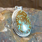 Handcrafted by Navajo artist L.P., this oval pendant features genuine #8 Turquoise set in sterling silver. 