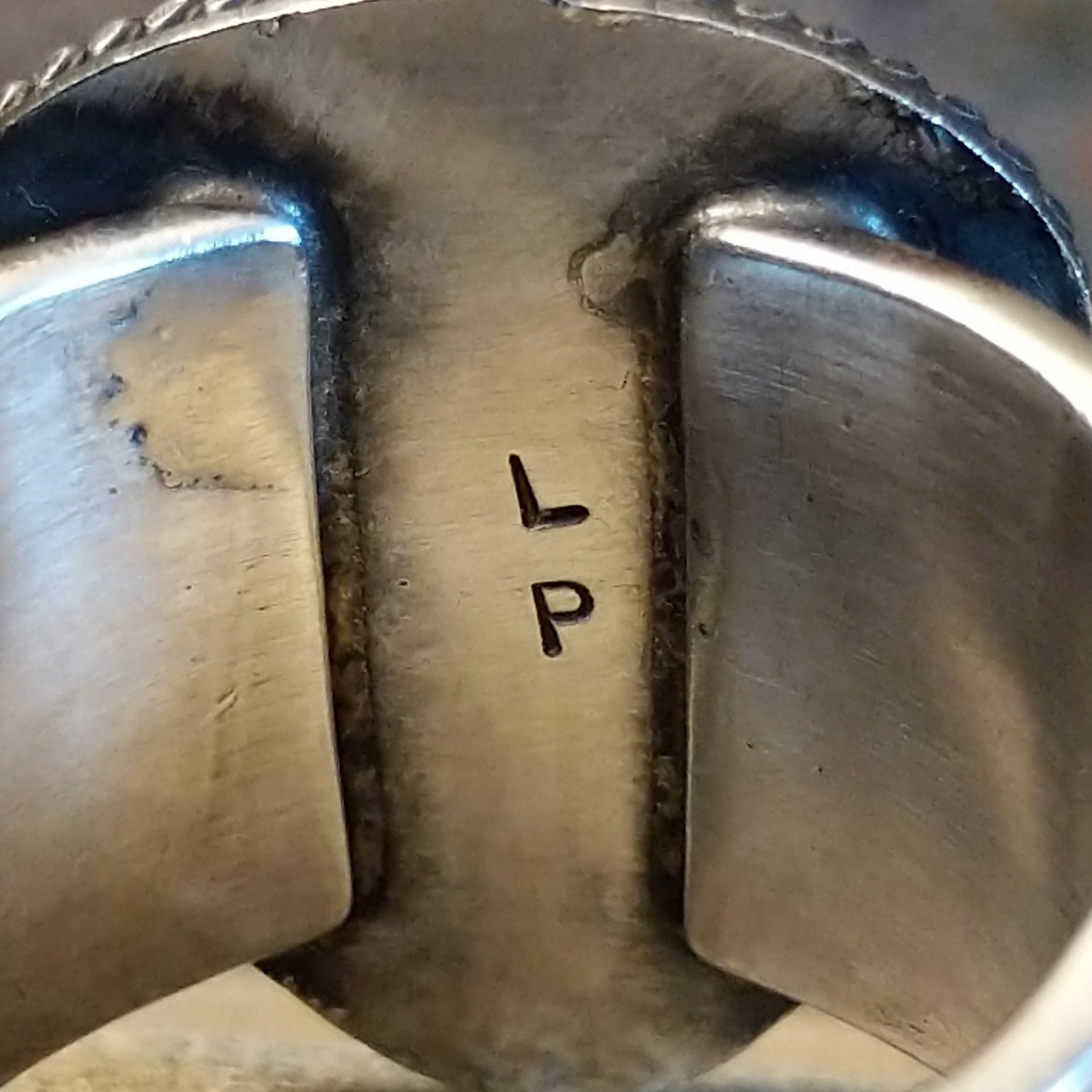 Artisan stamp on underside of ring.