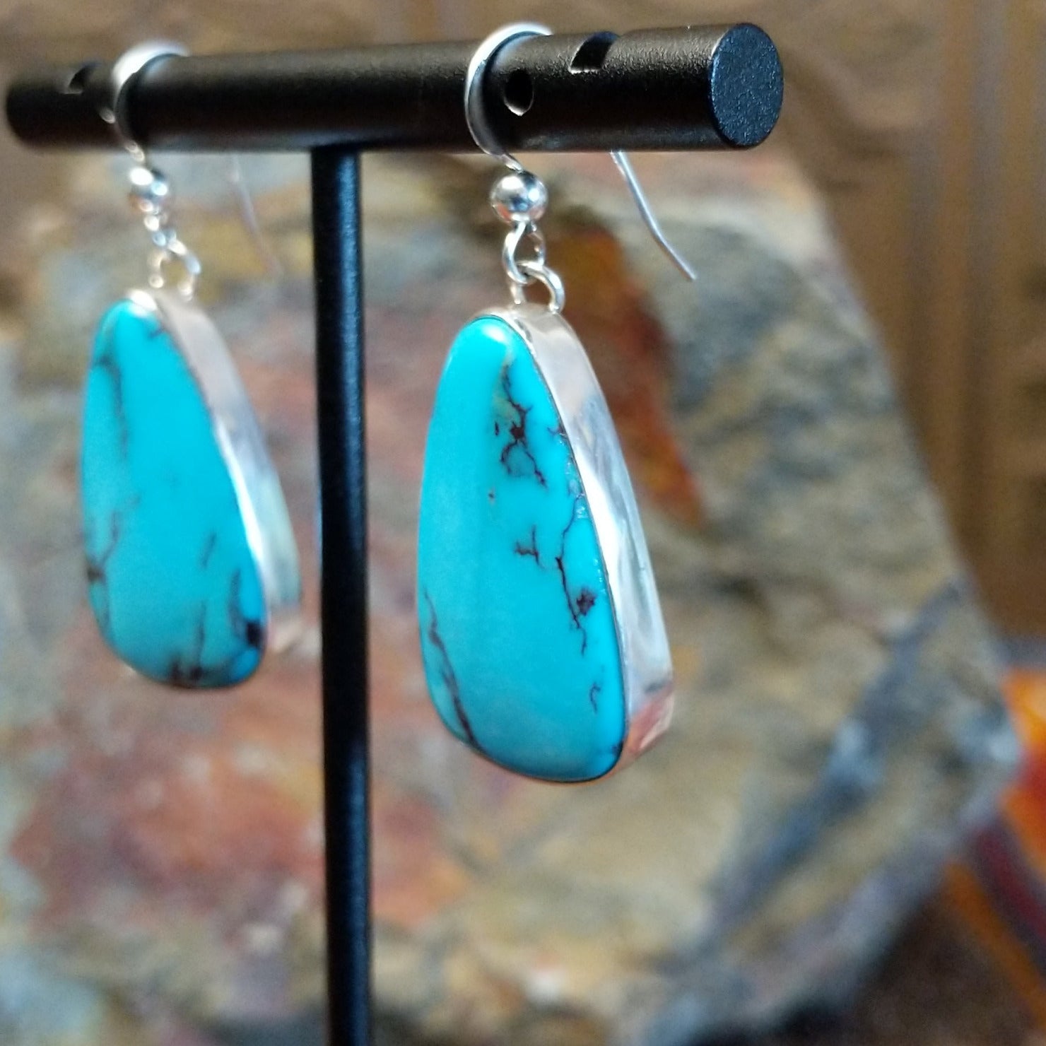 Kingman turquoise earrings by Navajo artists Everett & Mary Teller with deep burgundy matrix, side view.