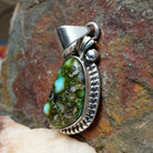 Sonoran Gold turquoise pendant by Navajo artist Verna Blackgoat, handcrafted in sterling silver with a scalloped setting, side view.