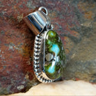 Sonoran Gold turquoise pendant by Navajo artist Verna Blackgoat, handcrafted in sterling silver with a scalloped setting, side view.