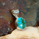Sonoran Gold turquoise round pendant by Navajo artist Fred Guerro Jr., is handcrafted in sterling silver, side view.