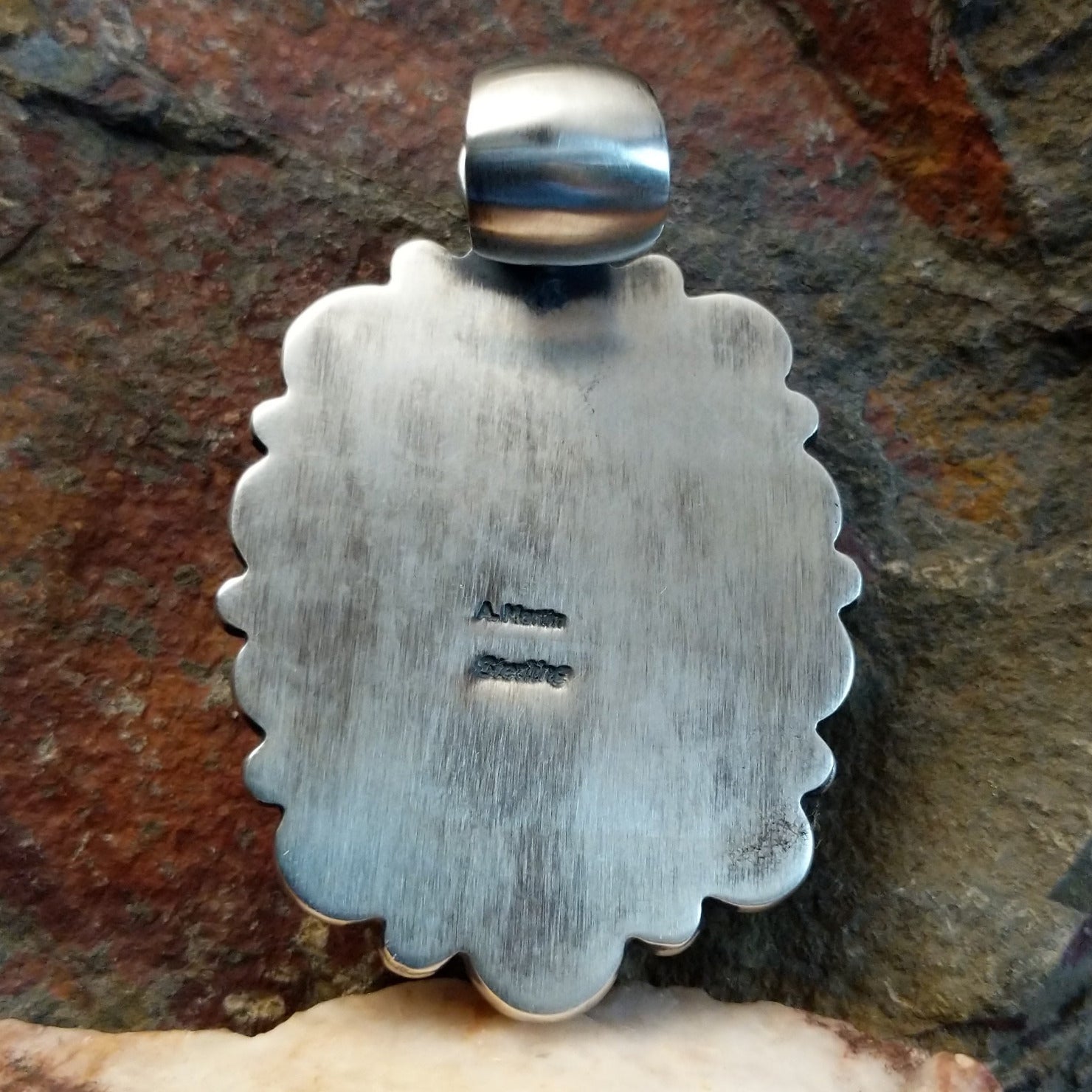 Artisan and Sterling Silver stamp on back of pendant.