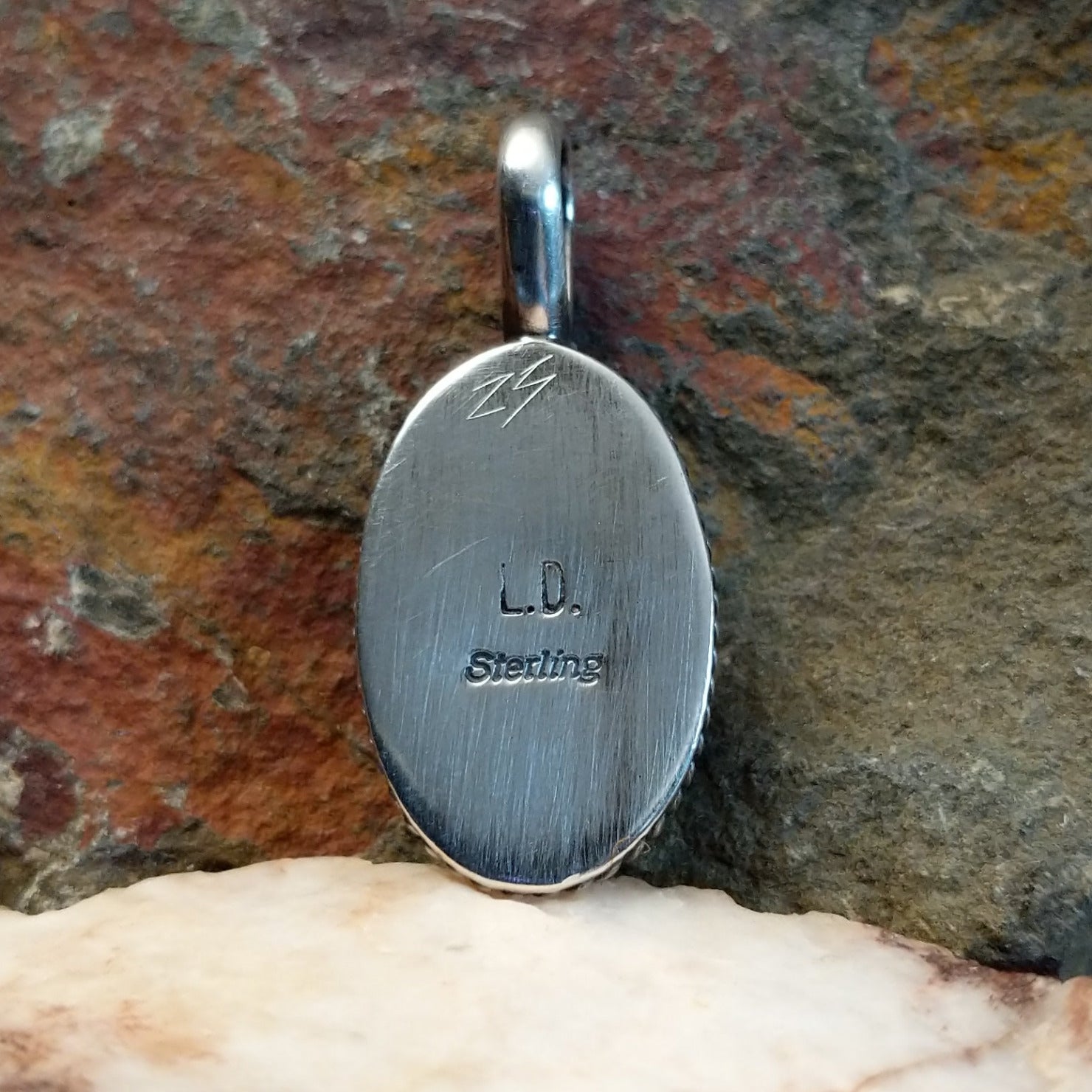 Artisan and Sterling Silver stamp on back of pendant.