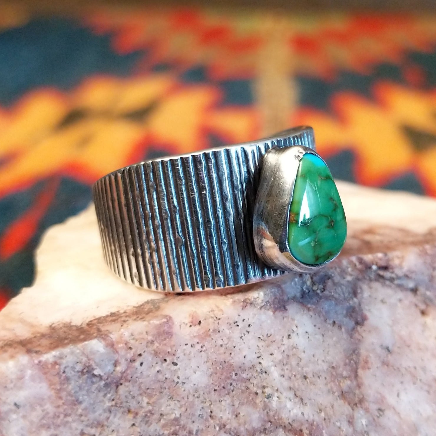 Sonoran Gold Turquoise stone in a teardrop shape. Made by Elgin Tom, this ring is size 9 and set in Sterling Silver; side view.