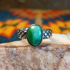  Sonoran Gold Turquoise stone in a detailed crosshatch band setting, set in sterling silver. Made by Raymond Coriz, this ring is size 7.5, front view.