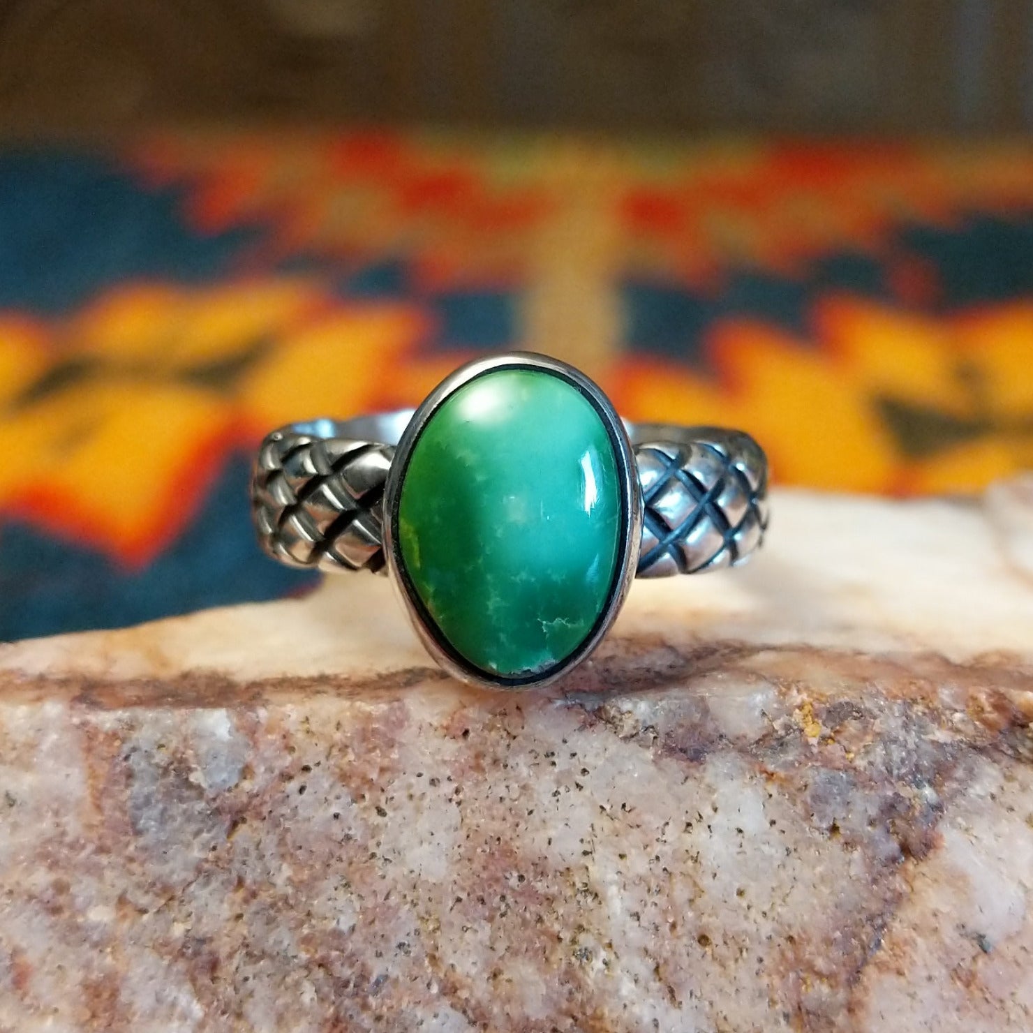  Sonoran Gold Turquoise stone in a detailed crosshatch band setting, set in sterling silver. Made by Raymond Coriz, this ring is size 7.5, front view.