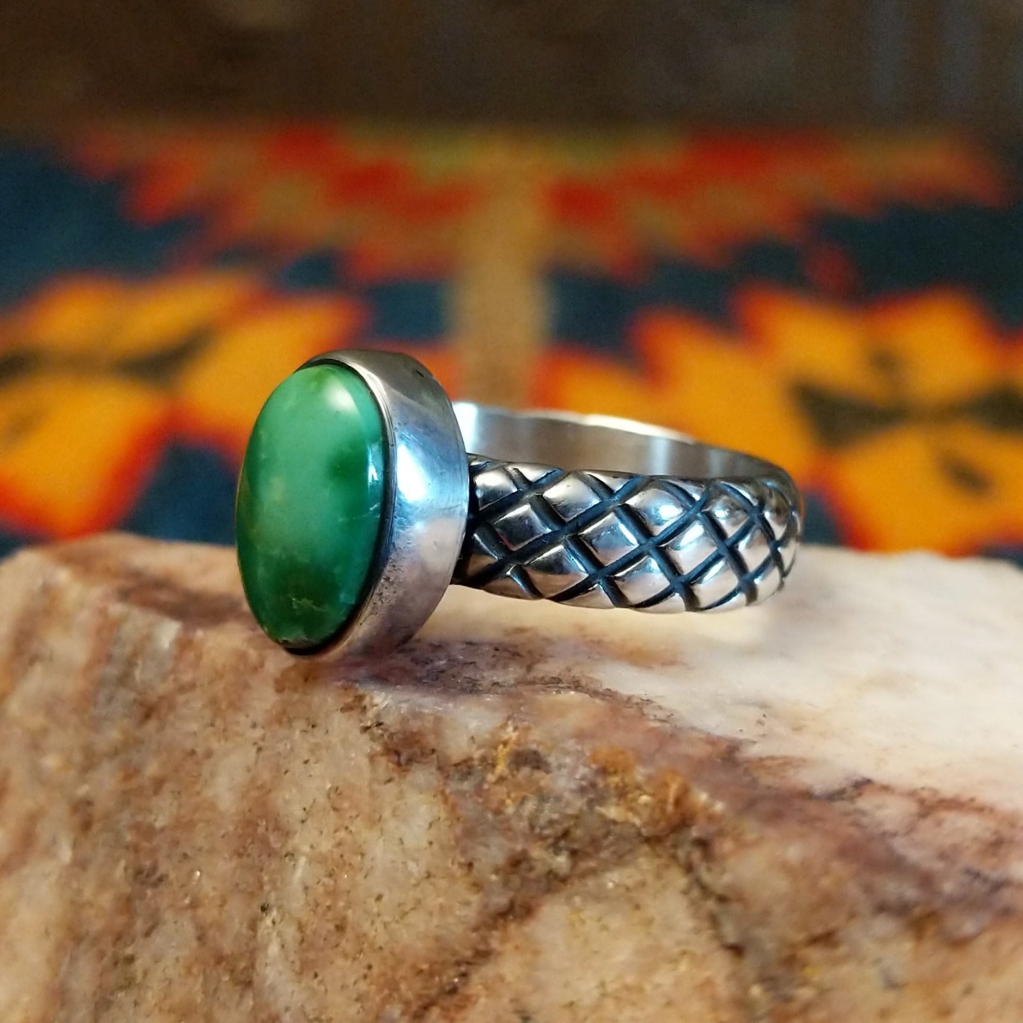  Sonoran Gold Turquoise stone in a detailed crosshatch band setting, set in sterling silver. Made by Raymond Coriz, this ring is size 7.5, side view.
