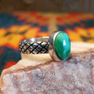  Sonoran Gold Turquoise stone in a detailed crosshatch band setting, set in sterling silver. Made by Raymond Coriz, this ring is size 7.5, side view.
