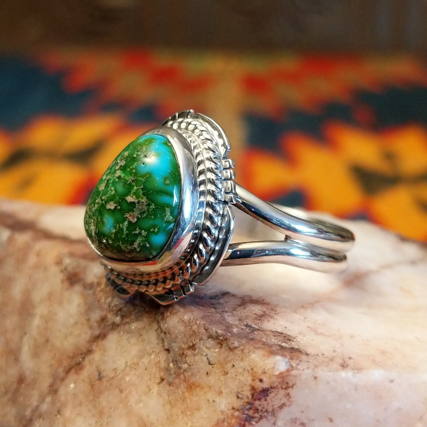 Sonoran Gold Turquoise stone set in etched sterling silver, with a classic rope design. Made by Jake Sampson, this ring is size 8, side view.