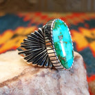 Sonoran Gold Turquoise stone in an ovoid shape, set in Sterling Silver. Made by Raymond Coriz, this ring is size 12, side view with band detail.