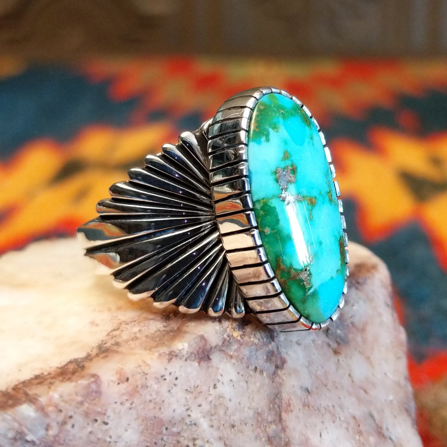 Sonoran Gold Turquoise stone in an ovoid shape, set in Sterling Silver. Made by Raymond Coriz, this ring is size 12, side view with band detail.