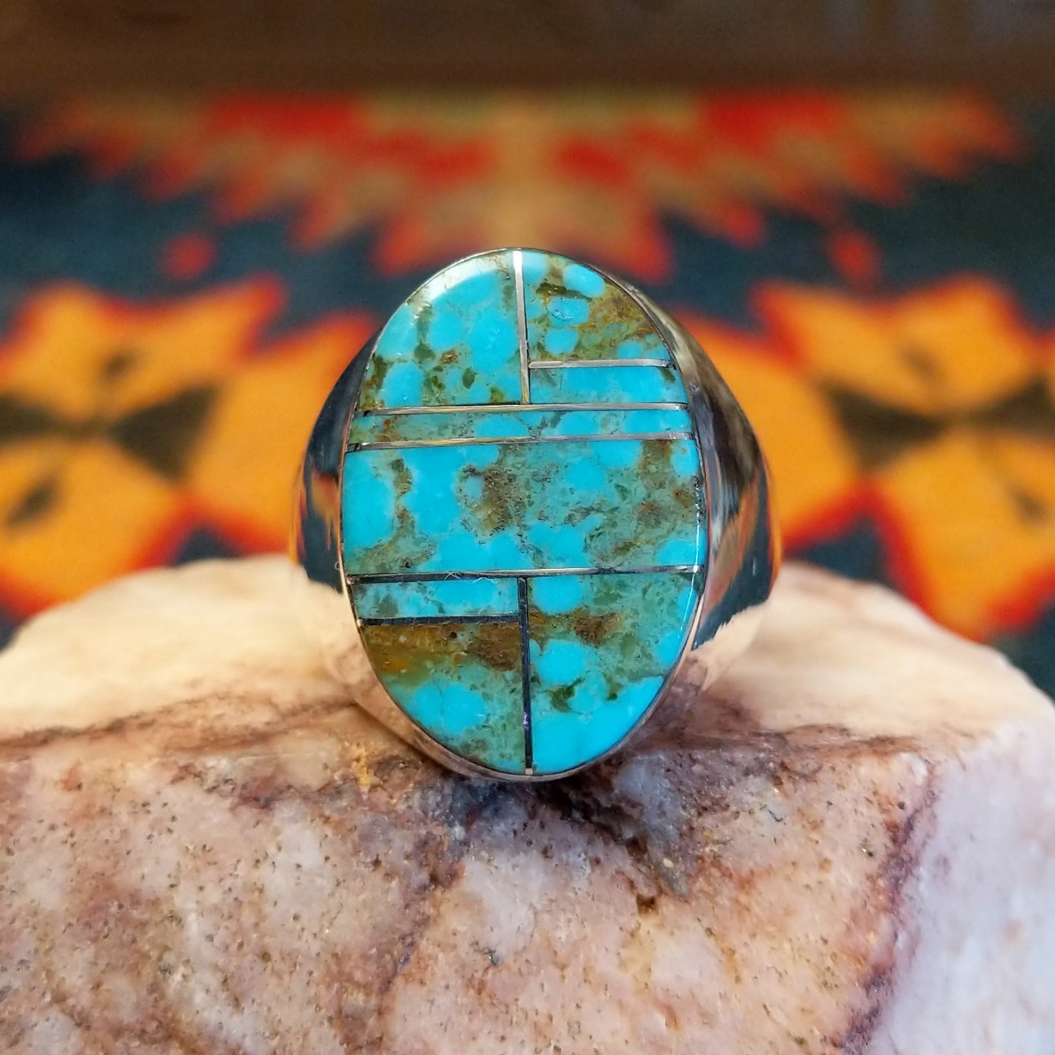 Size 11.5 ring by Wilbert Grey, features a bold oval inlay of vibrant turquoise set in sterling silver.  Front View