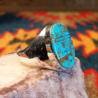 Size 11.5 ring by Wilbert Grey, features a bold oval inlay of vibrant turquoise set in sterling silver. Side view