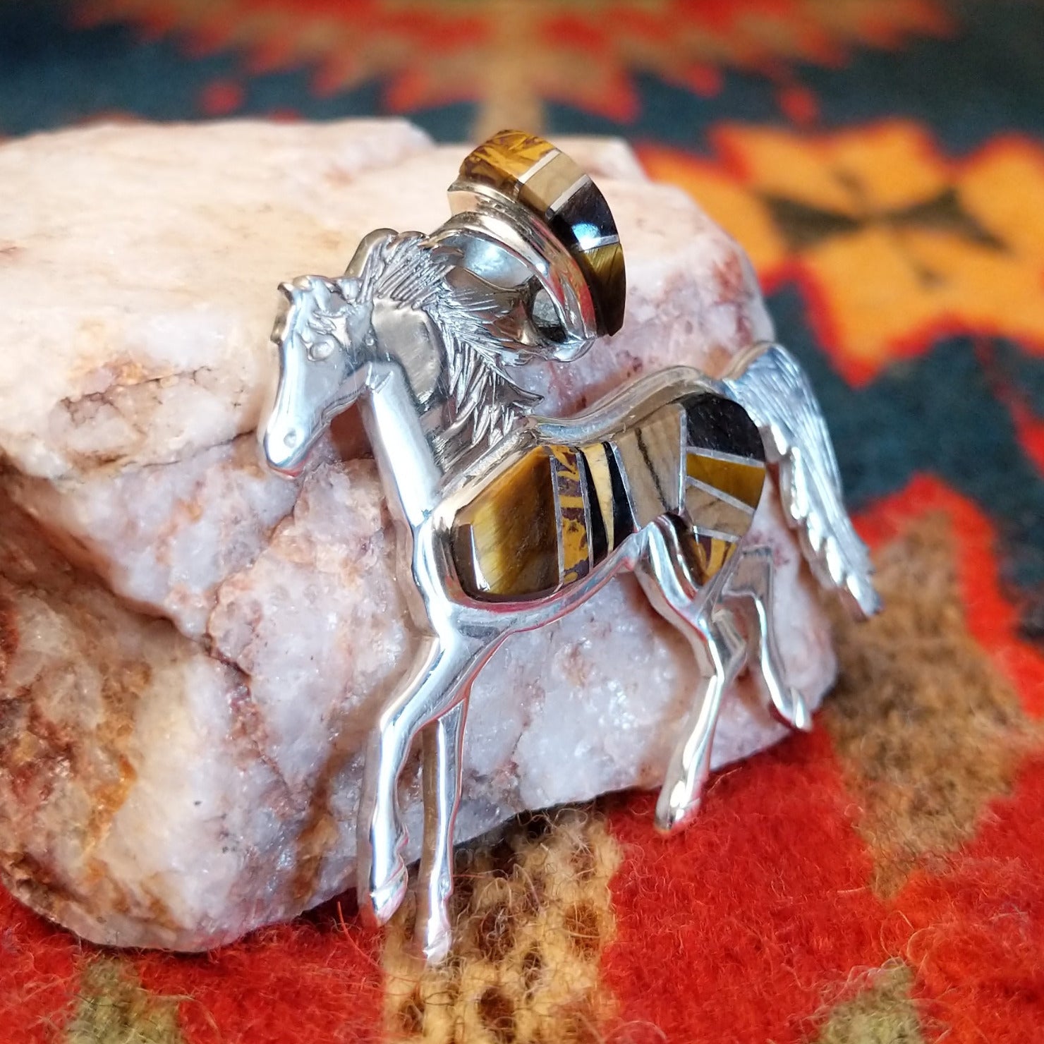 Navajo horse pendant handcrafted in sterling silver and showcases a dynamic inlay of Tiger’s Eye, Black Onyx, and Picture Jasper.  Side view
