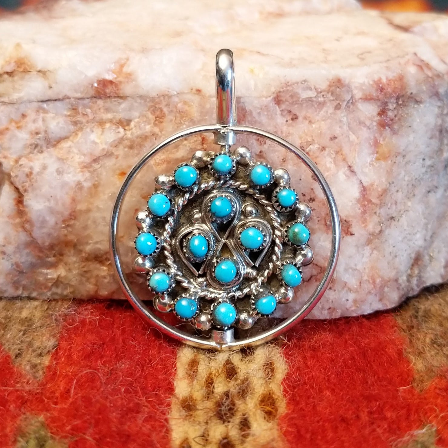  Navajo Turquoise and Coral Reversible Pendant features vibrant turquoise stones on one side, and coral on the other, set in sterling silver.  Front view of turquoise side.