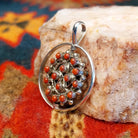  Navajo Turquoise and Coral Reversible Pendant features vibrant turquoise stones on one side, and coral on the other, set in sterling silver.  Coral side view.