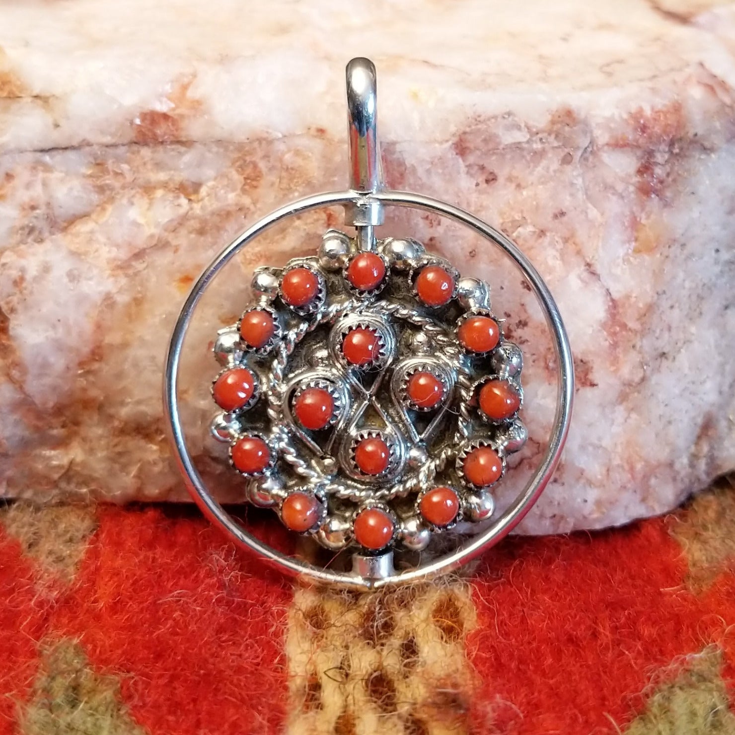  Navajo Turquoise and Coral Reversible Pendant features vibrant turquoise stones on one side, and coral on the other, set in sterling silver.  Coral front view