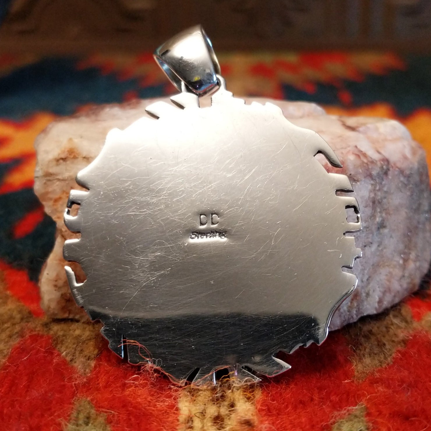 Artisan and Sterling Silver stamp on back of pendant.