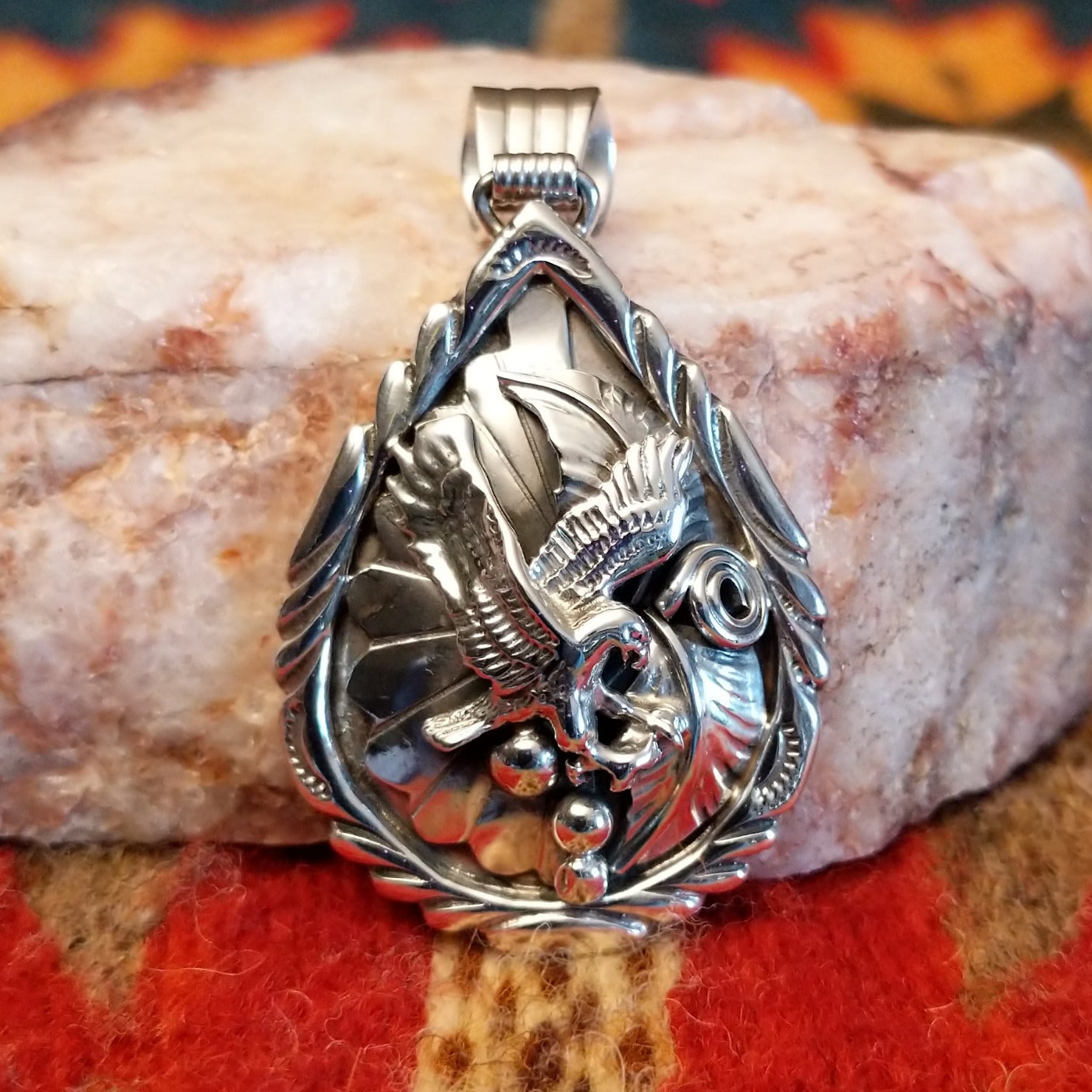 Navajo Eagle pendant  handcrafted in sterling silver, featuring a soaring eagle set within a feathered and scrollwork frame.  Front view