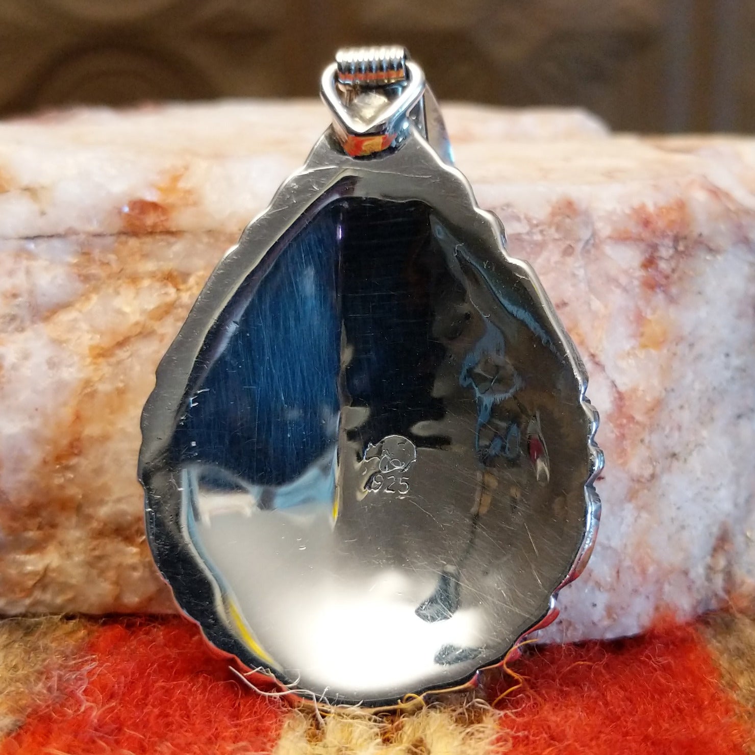 Artisan and sterling silver .925 stamp on back of pendant.