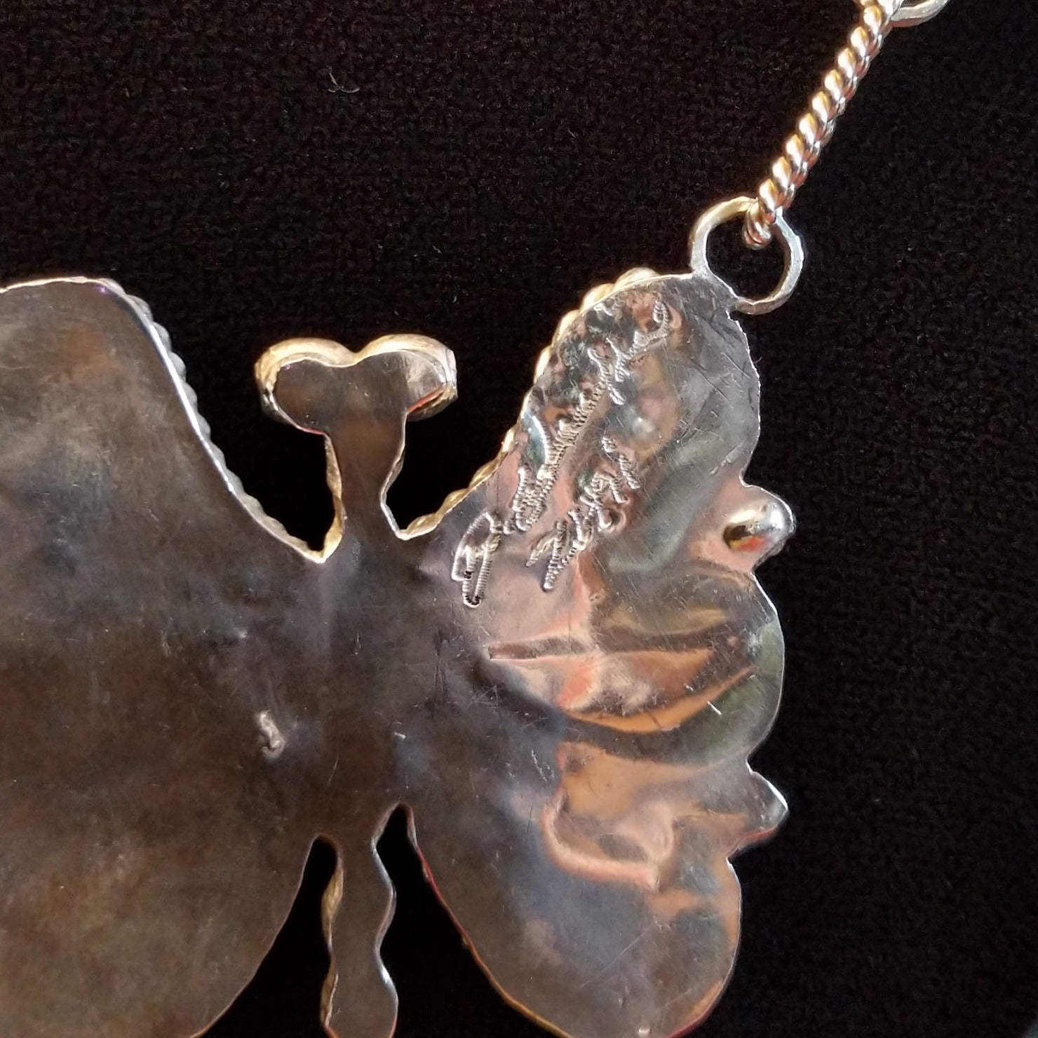 Close up of artisan hallmark on back of one part of the necklace.
